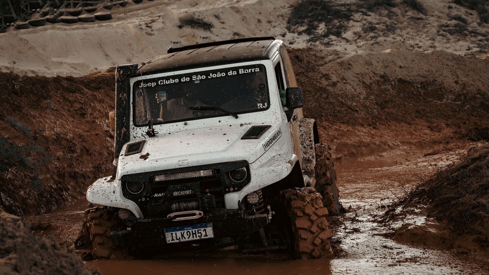 A capable 4x4 working through a muddy off-road track