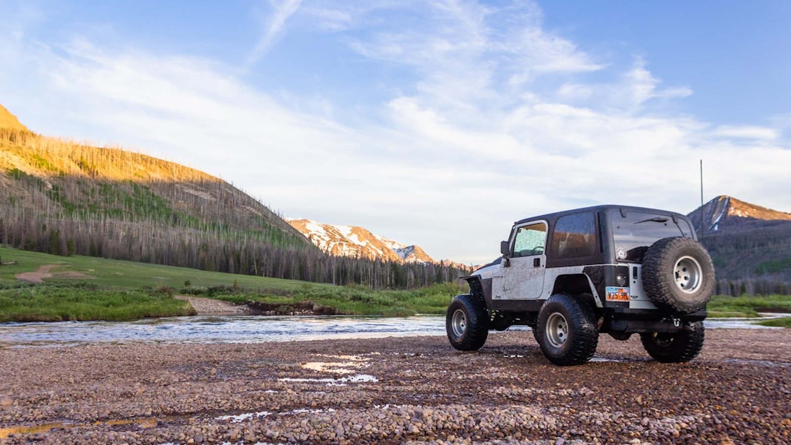A 4x4 parked and dripping after a successful river crossing on the trail