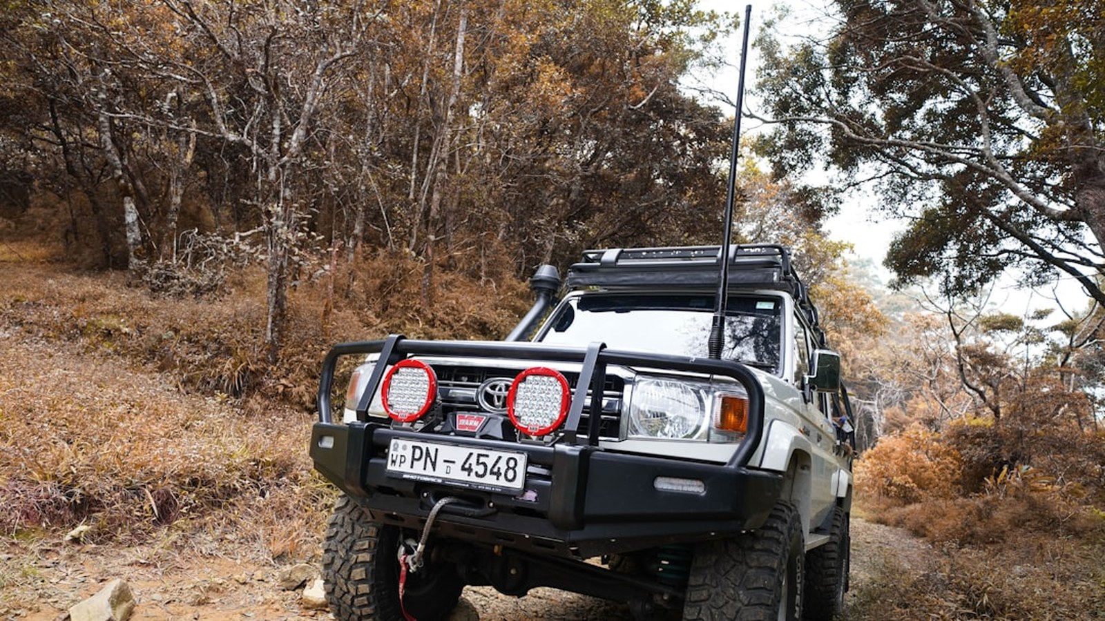 A modified 4x4 with a snorkel intake parked in an off-road setting