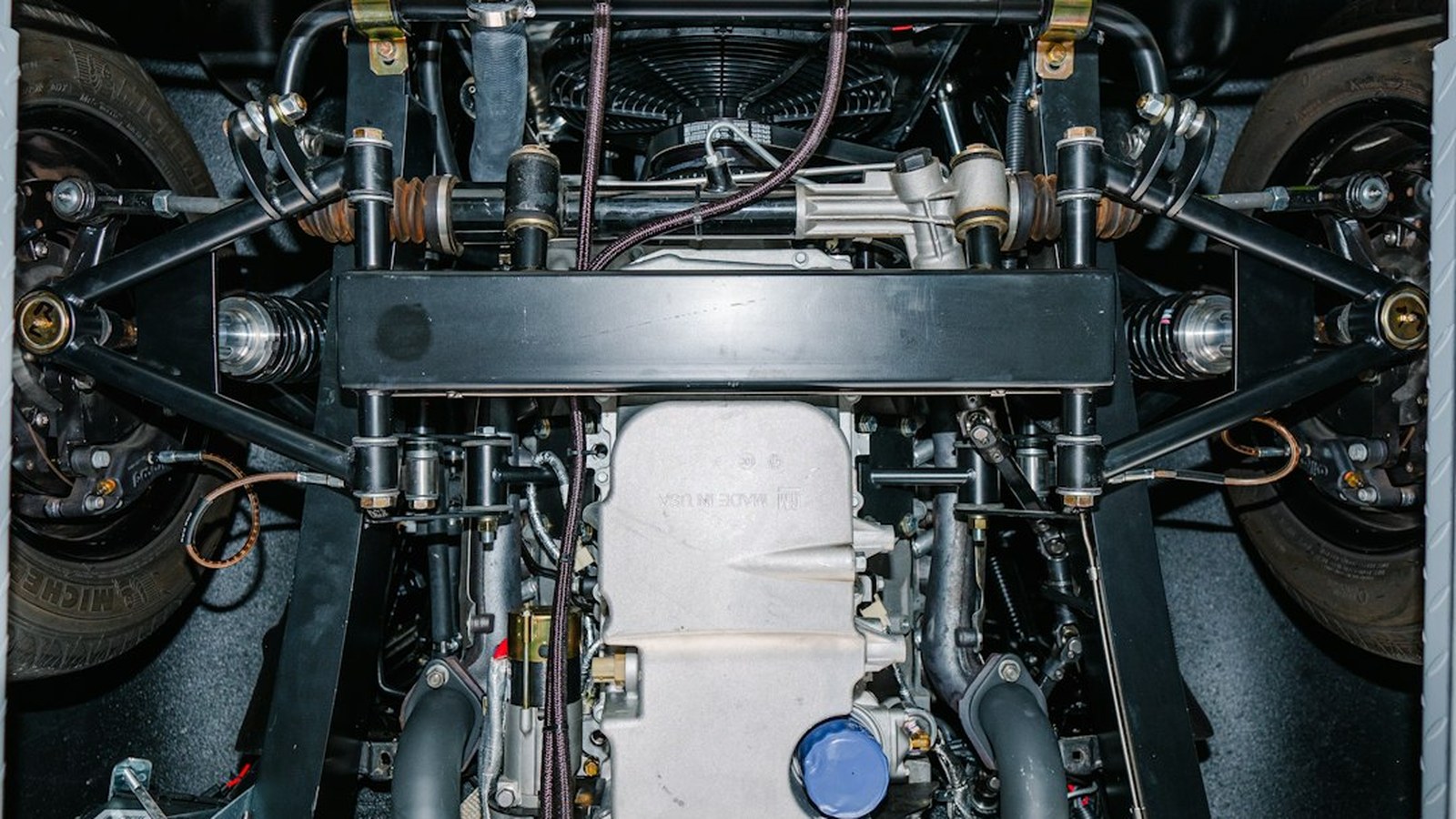 An undercarriage view of a 4x4 showing the oil pan, suspension control arms, axles, and drivetrain components
