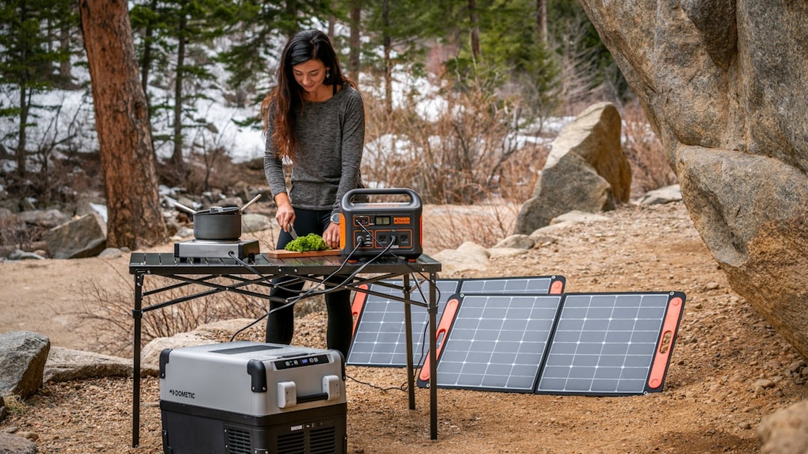 Portable power station with a solar panel at a lakeside overland camp