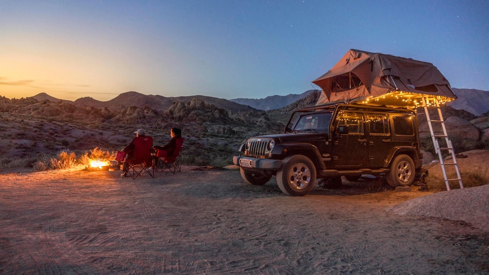 A 4x4 with a rooftop tent camped in the desert at dusk, far from anywhere