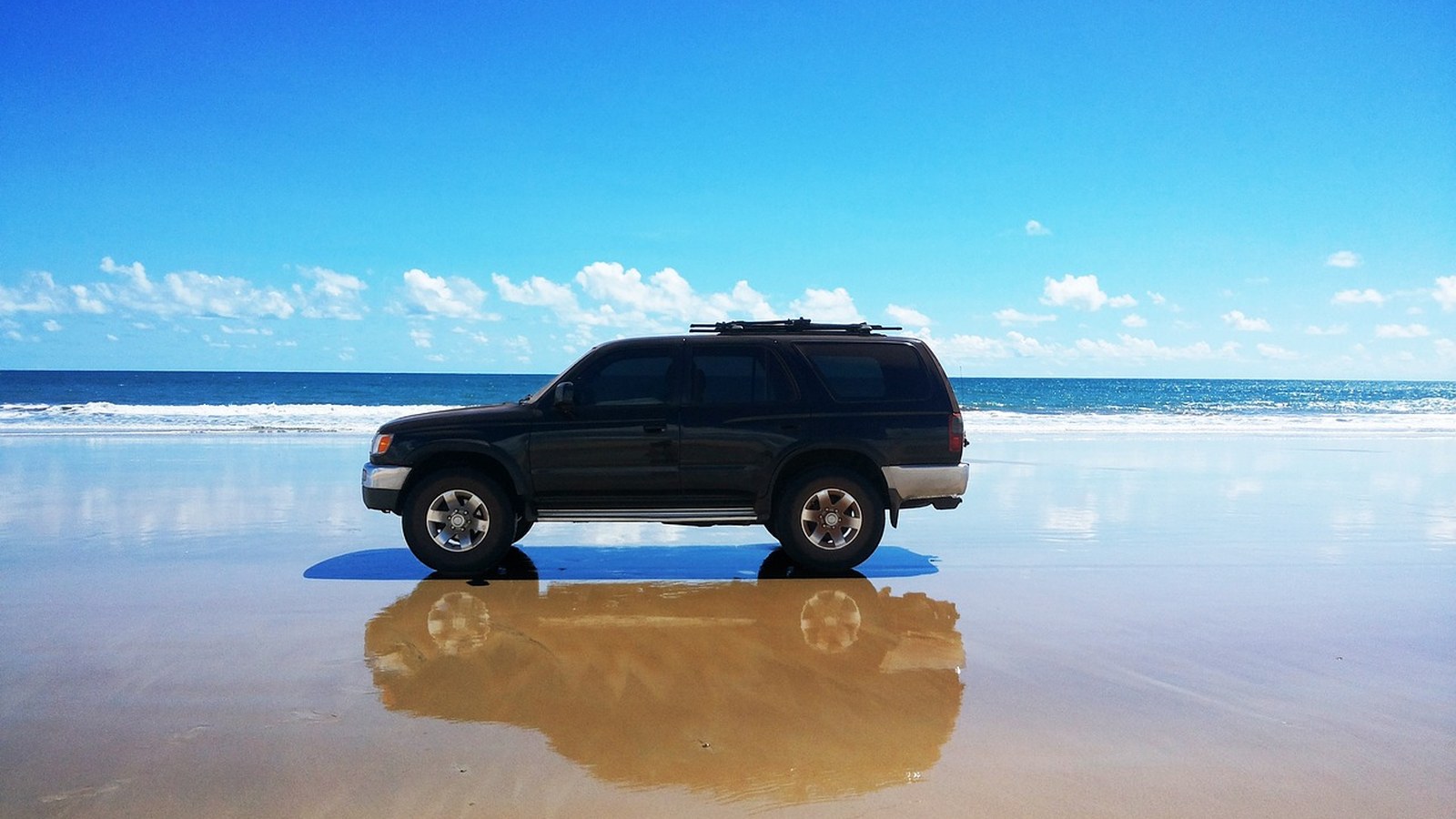 A 4x4 parked alone on a wild, remote shoreline before heading out on a solo trip.