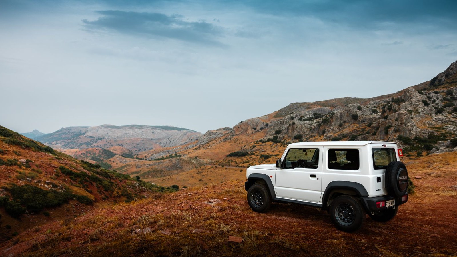 A 4x4 parked on a rugged ridge overlooking a sweeping valley on a family overland trip.