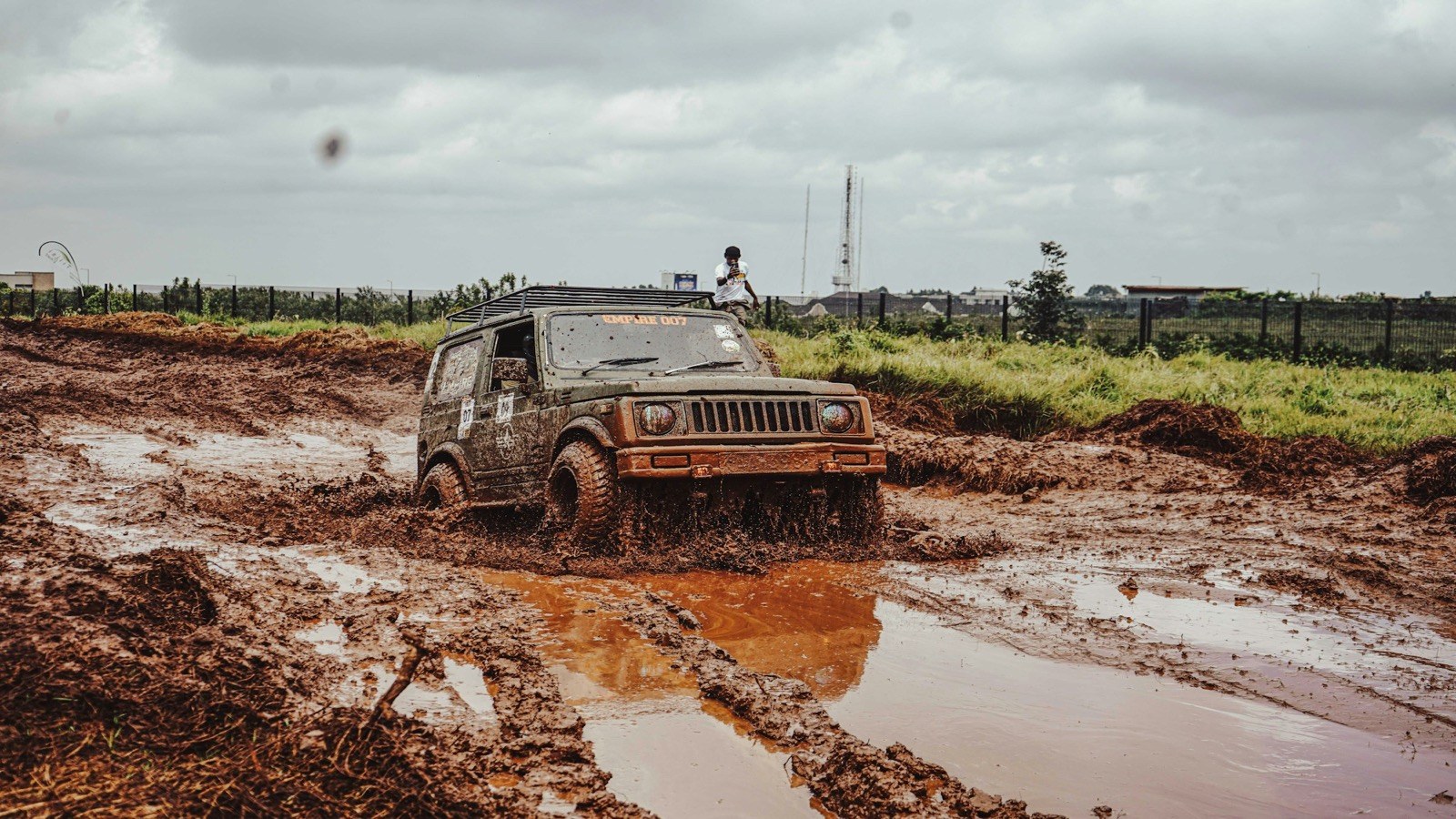 A mud-covered 4x4 buried in deep red mud on a trail