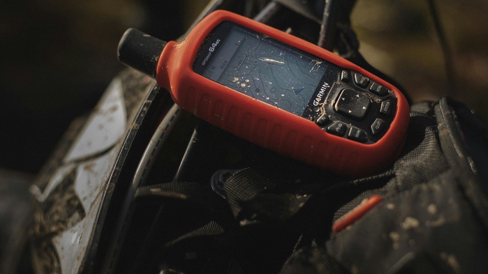 A rugged handheld GPS unit showing a map screen out in the field
