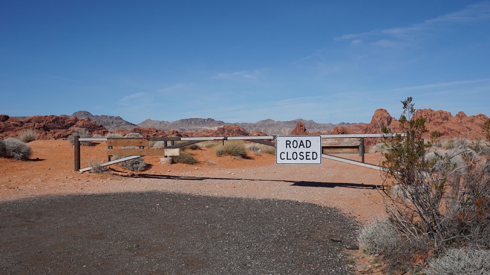 A road closed gate blocking a dirt road into a desert state park