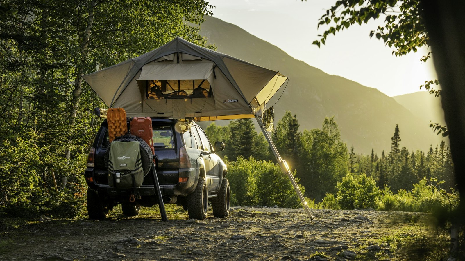 A 4x4 with a rooftop tent and a side awning extended over camp on poles