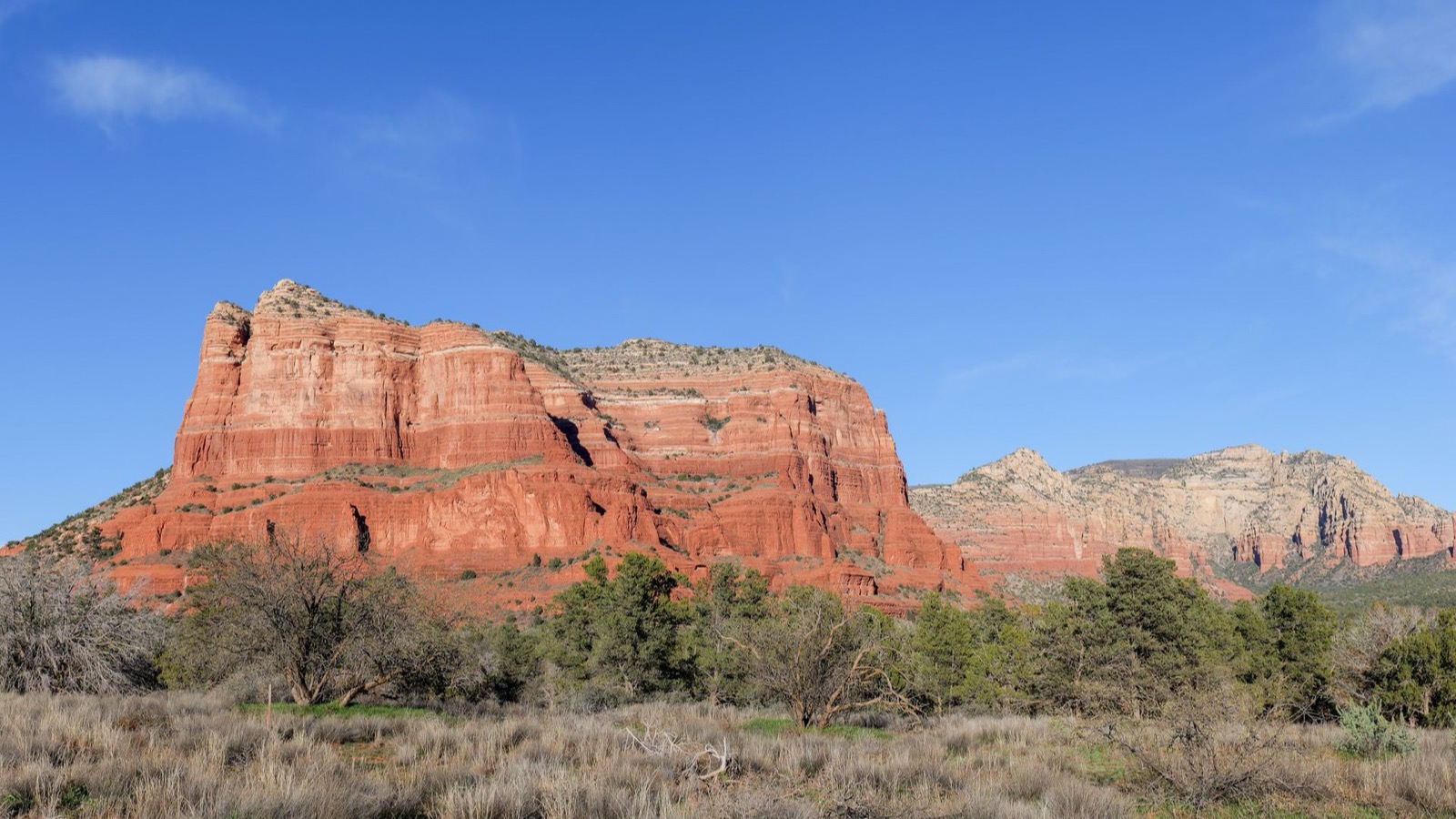 Layered red sandstone buttes rising above the high-desert scenery of Sedona's Red Rock Country