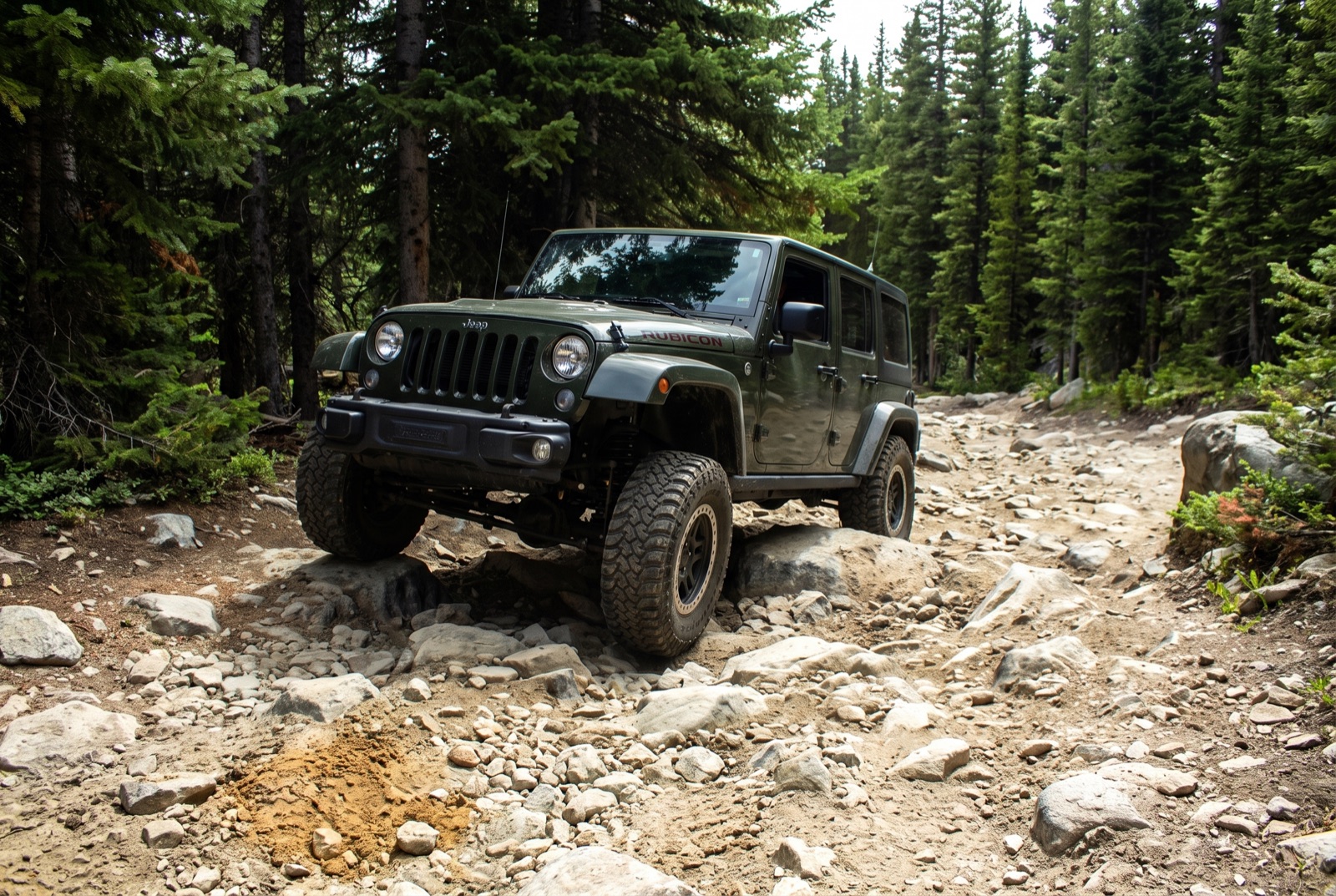A high-clearance 4x4 easing along the narrow dirt shore road that runs between the two Chinns reservoirs near the top of the climb