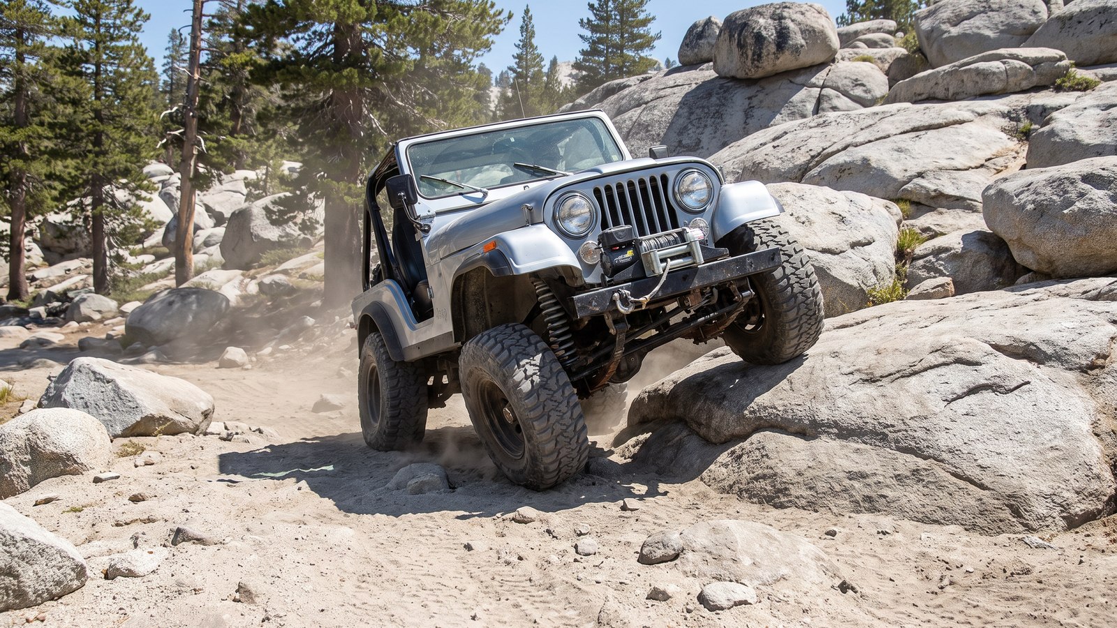 A built Jeep flexed over a gray granite boulder ledge on the Dusy-Ershim Trail, the kind of technical rock crawling that defines the route