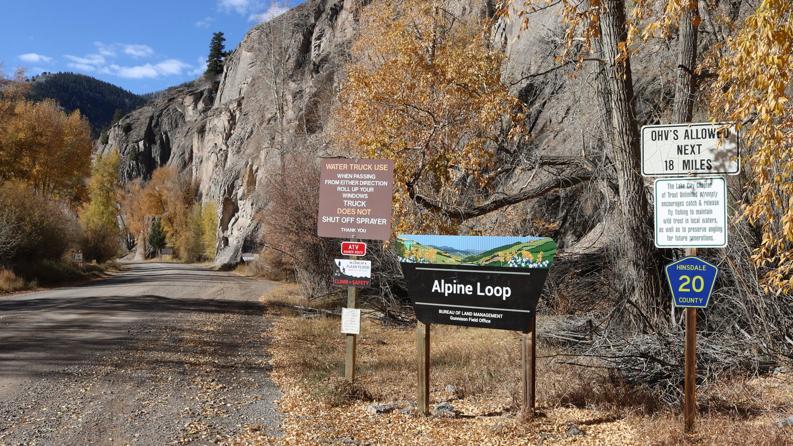 The Alpine Loop Backcountry Byway sign near Lake City marking the start of the high mining-road network, cottonwoods turning gold in early fall