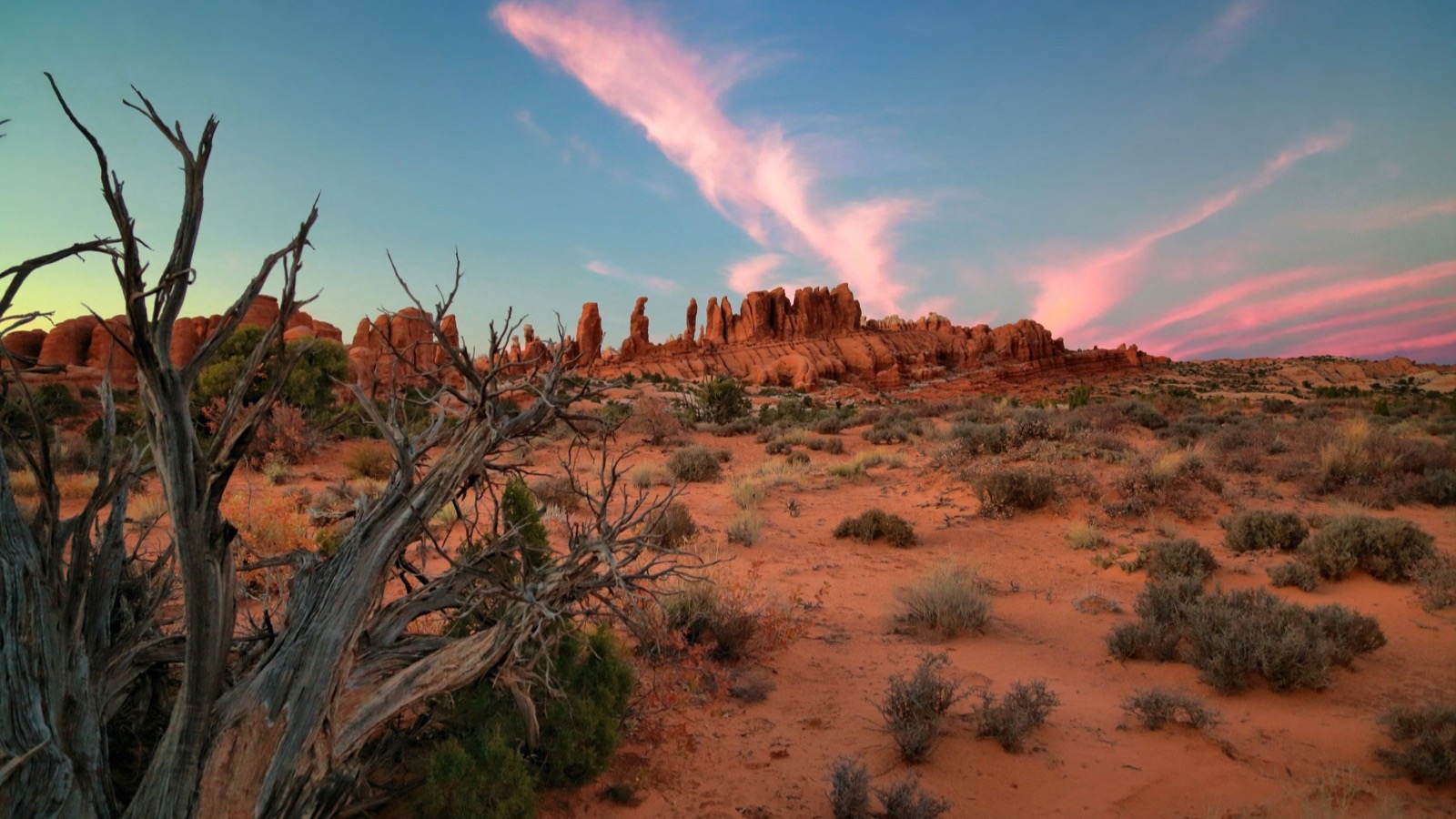 Red rock fins and spires glowing under a dramatic Moab sunset