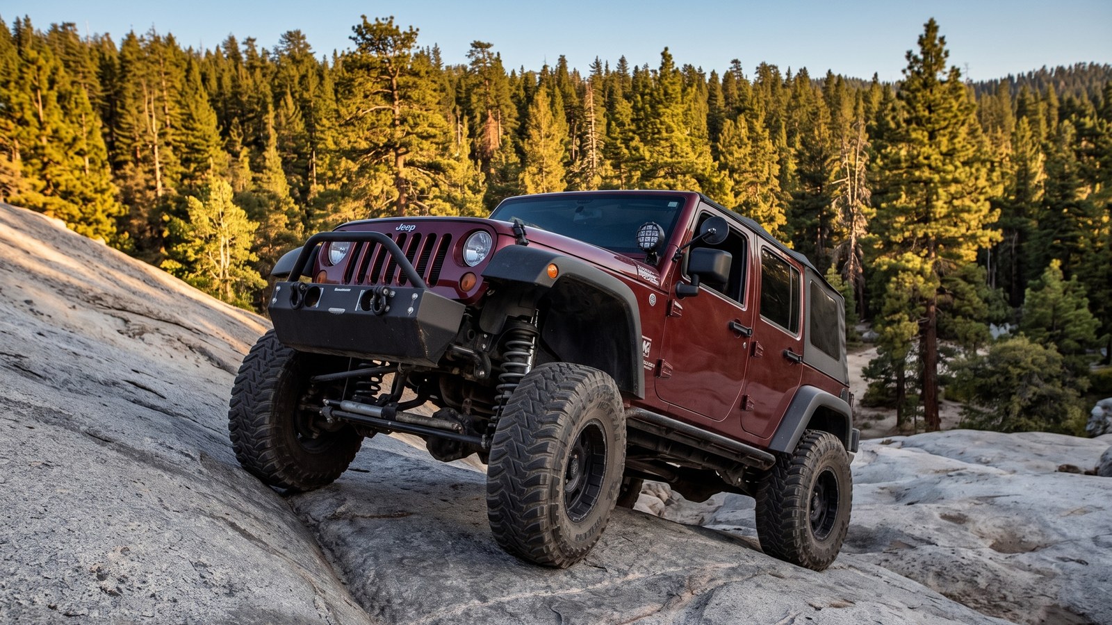 A modified 4x4 climbing the near-vertical granite slab at the Holcomb Creek free play area.