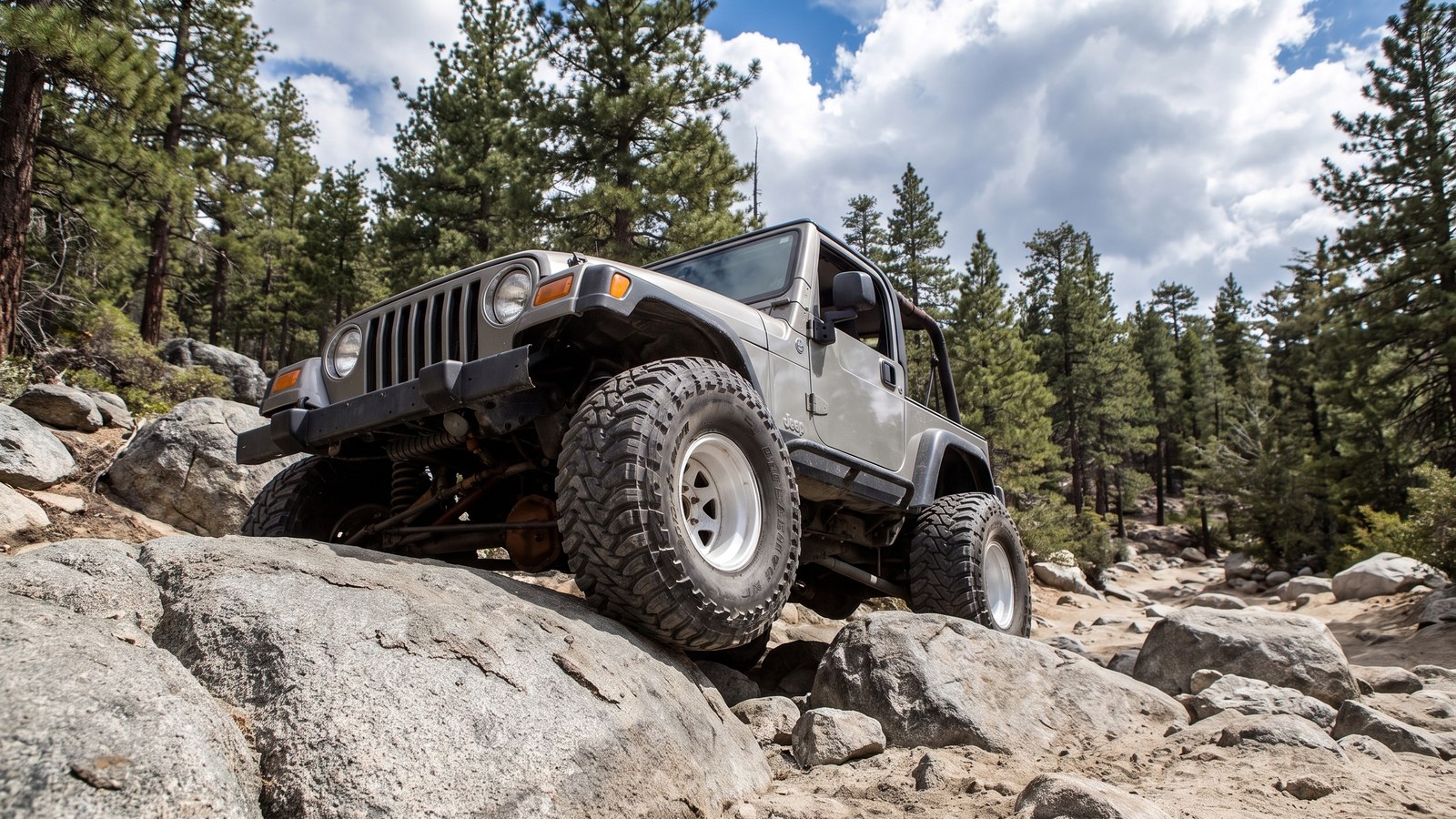 A low, dramatic angle of a 4x4 crawling the big granite boulders that define Holcomb Creek.