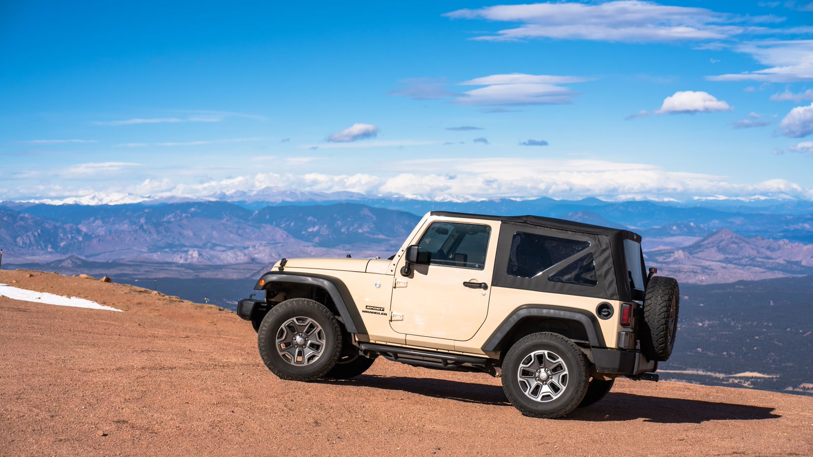 A 4x4 vehicle parked on a rocky summit with a sweeping panorama of the Colorado Rockies, the vast high-altitude terrain that defines a day in the Sawatch Range