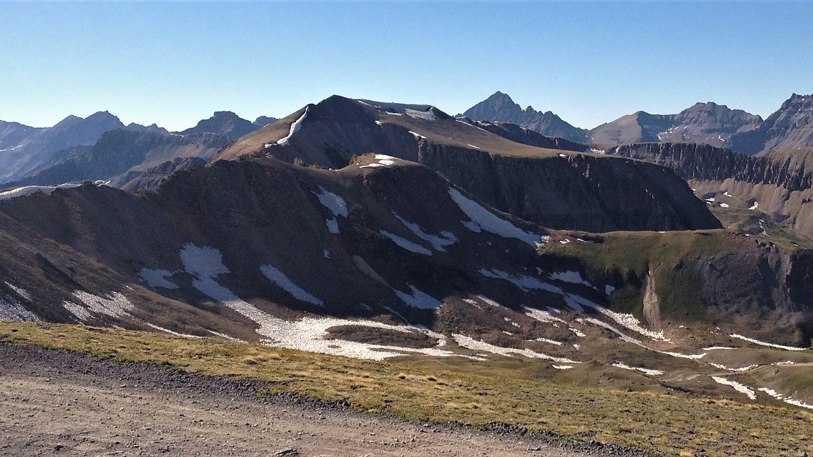 High alpine tundra, snowfields, and a panorama of jagged San Juan peaks near the crest of Imogene Pass