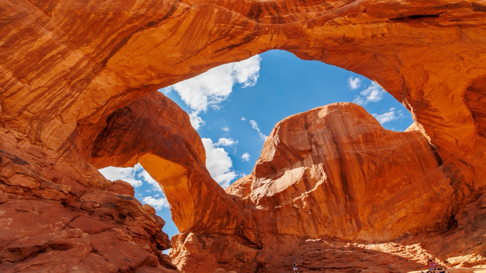 A massive sandstone arch in the red-rock fin country near the canyon, the kind of landmark visible from the trail