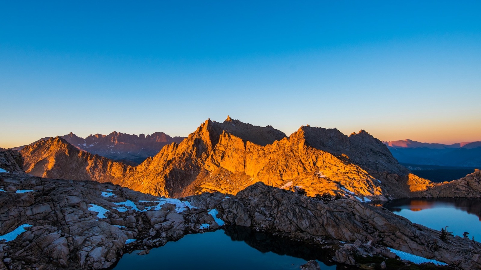 Granite peaks and alpine tarns glowing at sunrise in the high Sierra Nevada along the Rubicon Trail